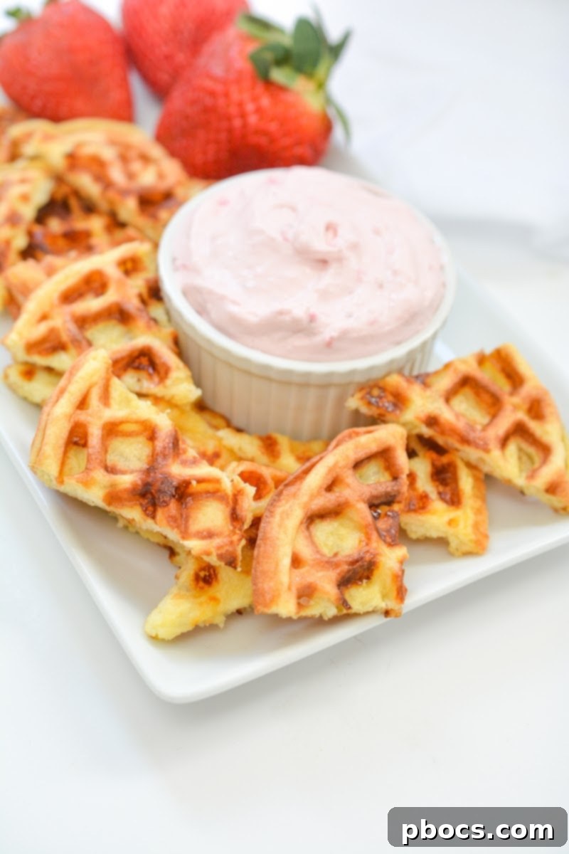 Strawberry Shortcake Chaffle Dippers with Keto Cream Dream 4 A plate of chaffle chips with three strawberries on it with a bowl of strawberry dip
