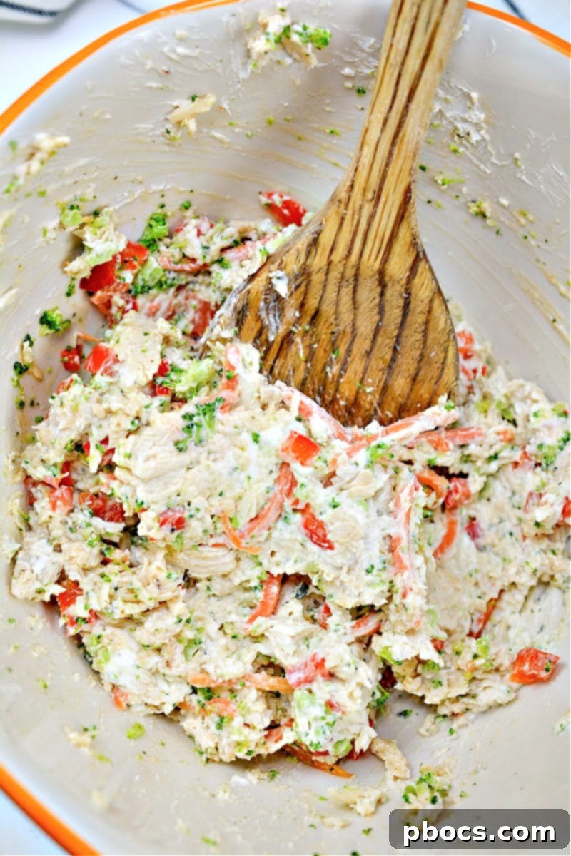 A large mixing bowl containing the cooked chicken and vegetable mixture with cream cheese and ranch seasoning.