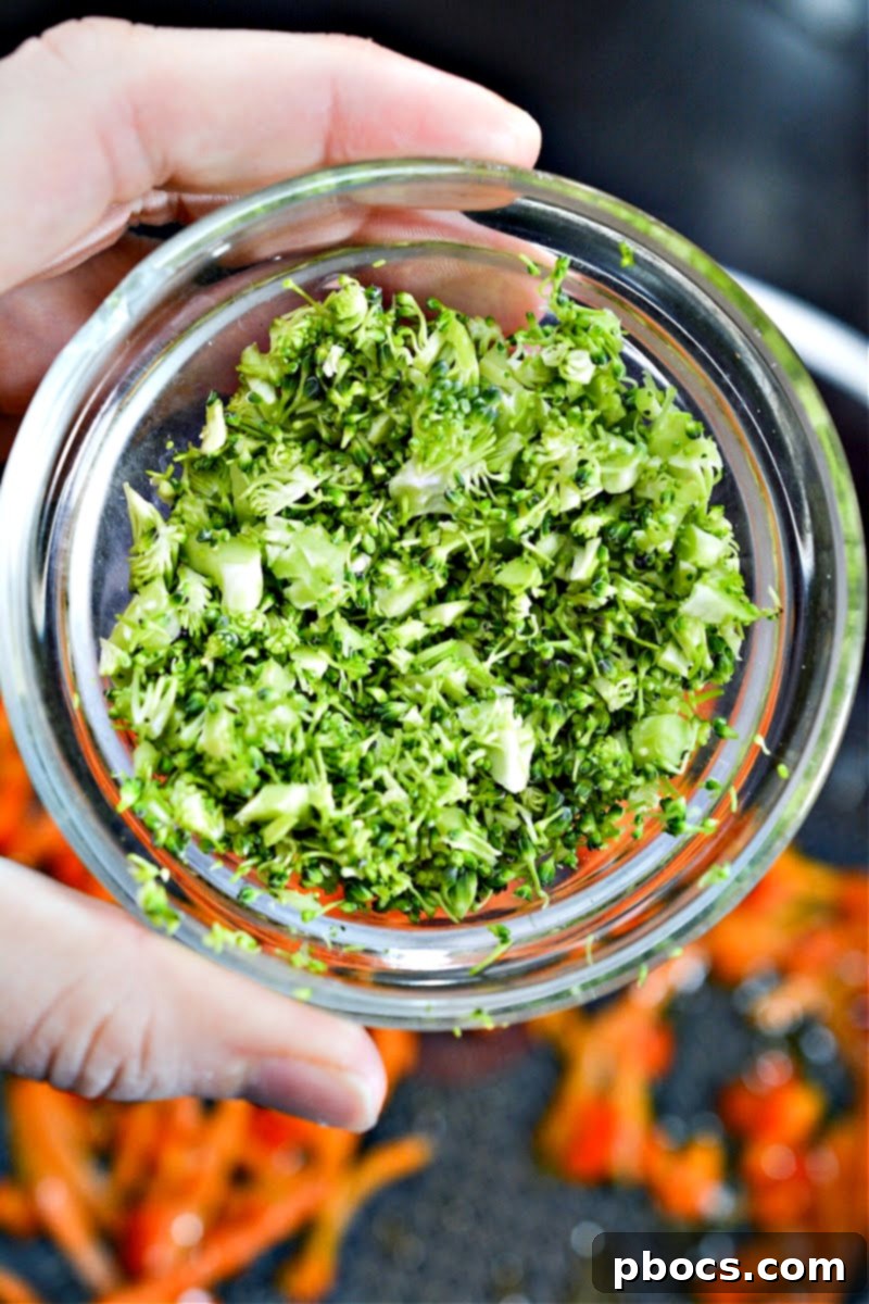 Finely chopped broccoli in a small white bowl, ready for cooking.