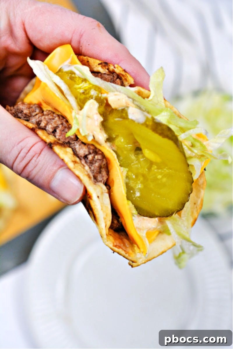 Holding a Keto Big Mac Smash Burger with pickles