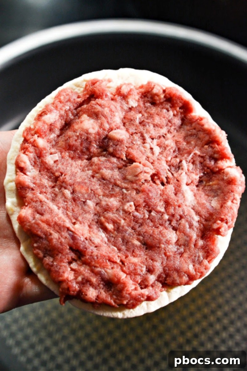 Raw hamburger meat on a keto tortilla
