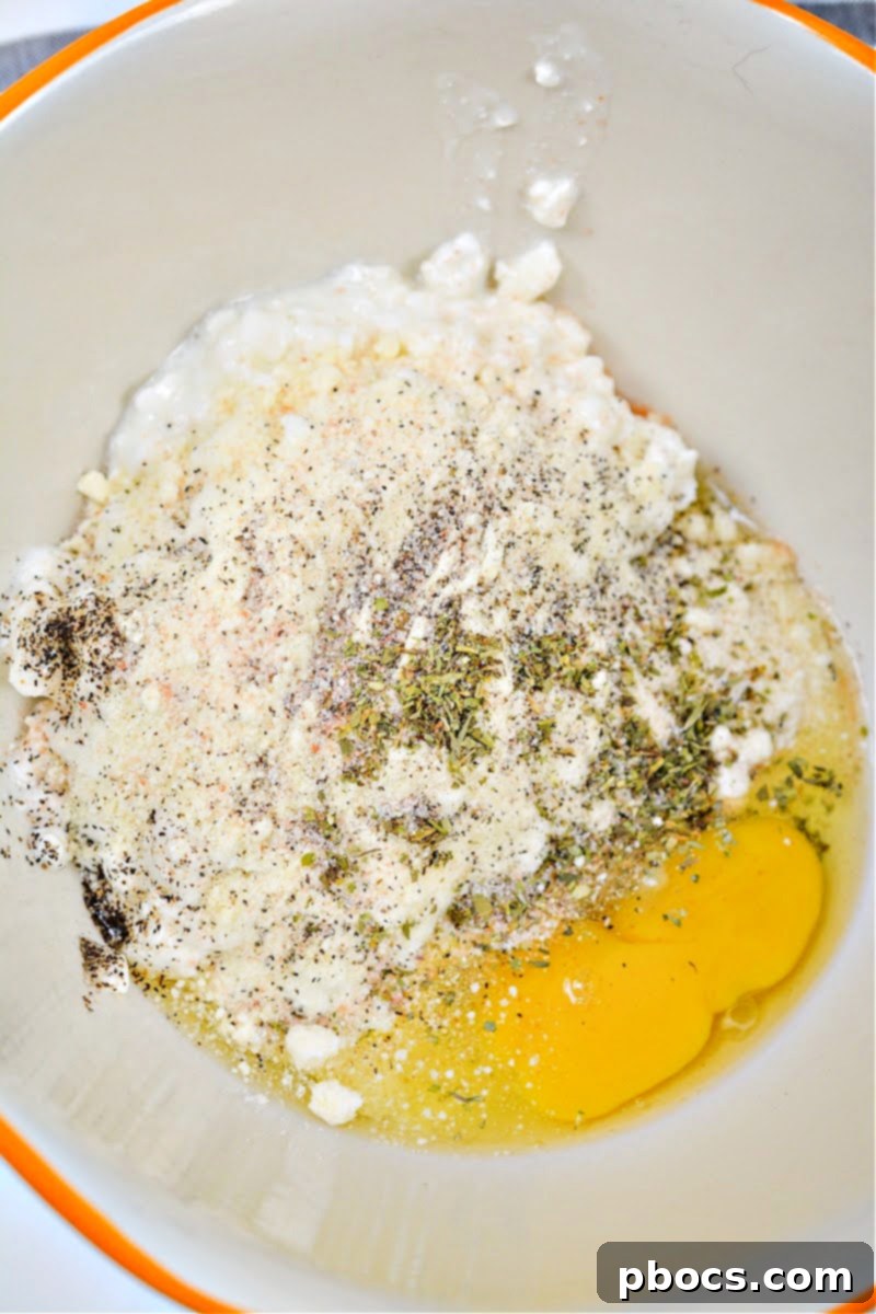 Cottage cheese, spices, and an egg in a mixing bowl