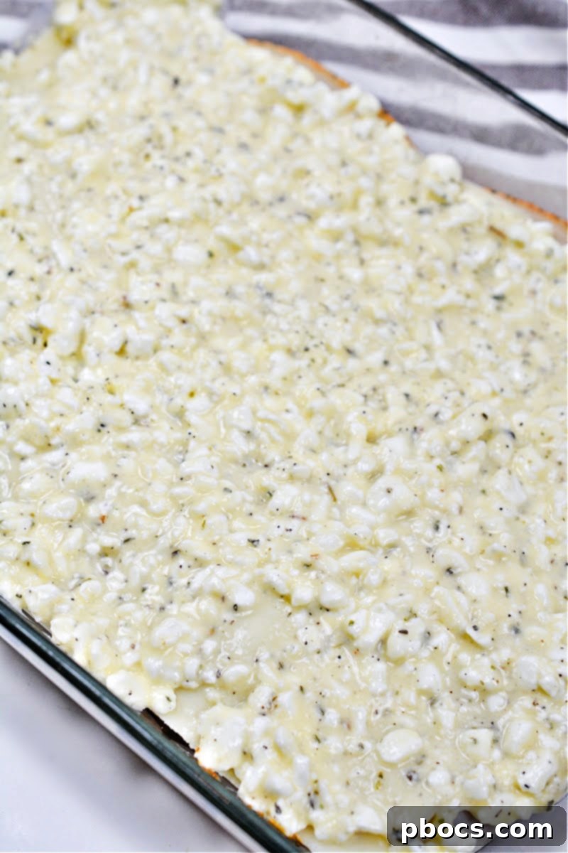Spreading the cottage cheese mixture over the mozzarella layer for Keto Protein Lasagna