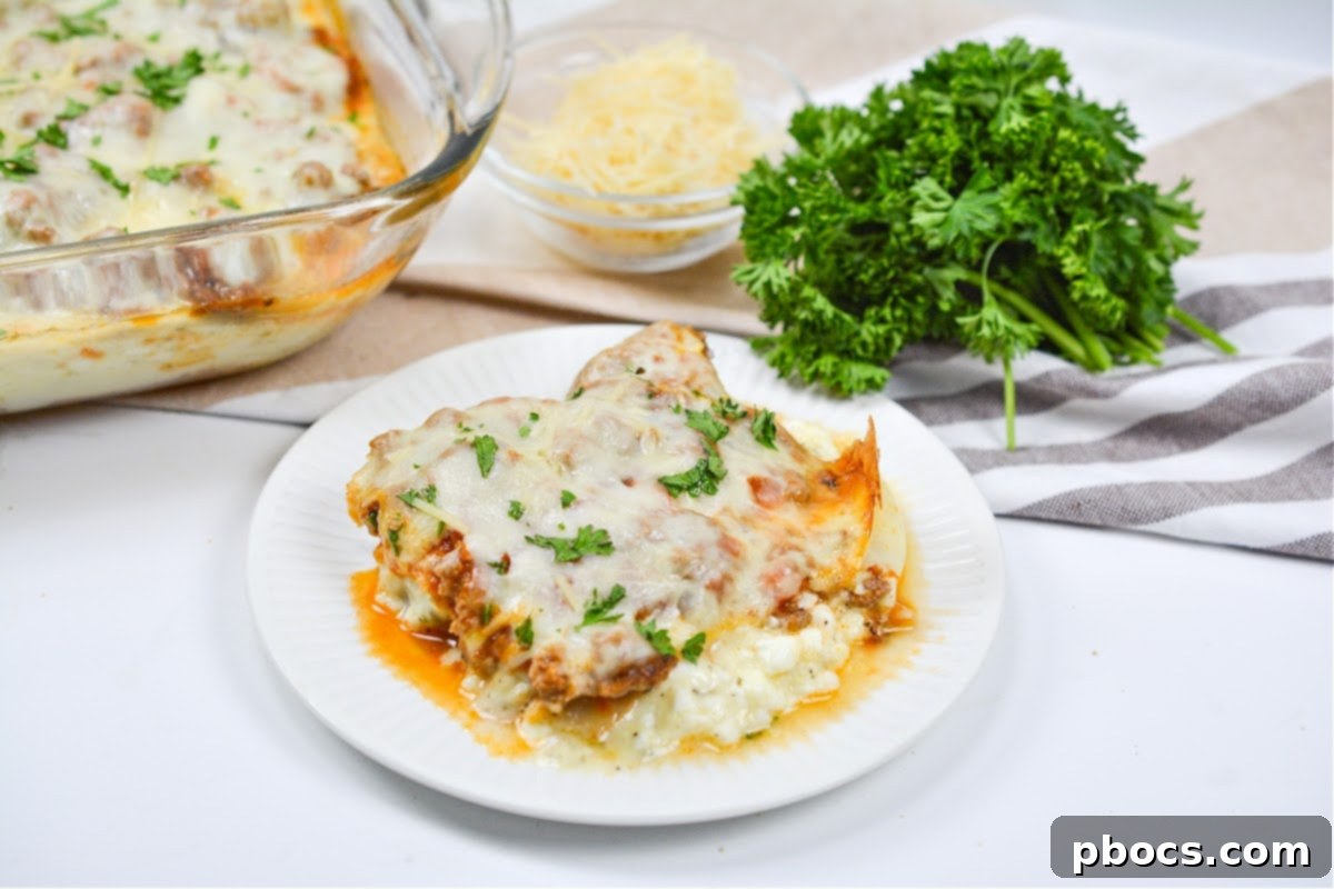 A slice of Keto Protein Lasagna on a plate, with the casserole dish in the background