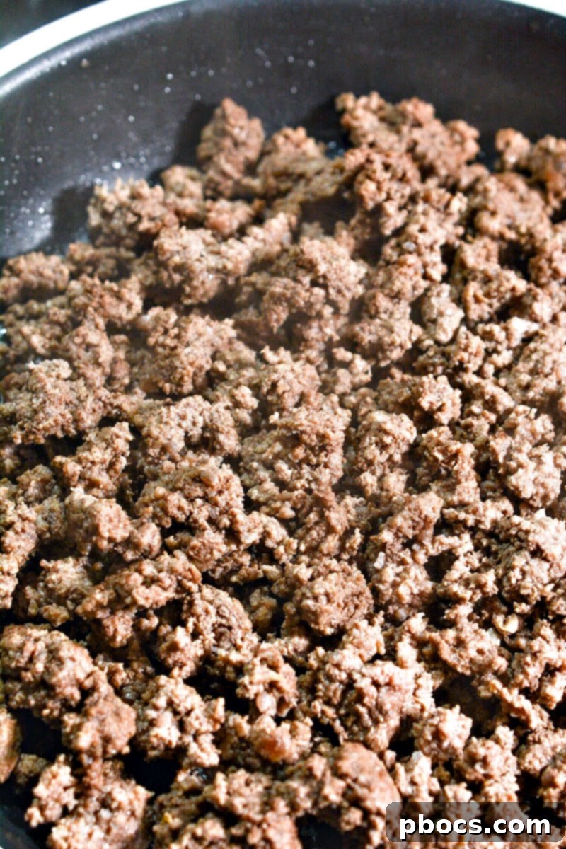 Ground beef cooking in a skillet on the stove