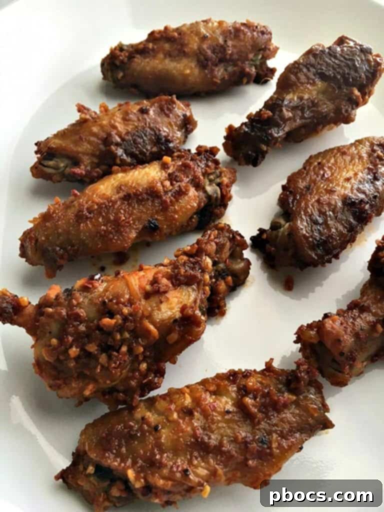 Golden-brown honey garlic pepper wings baking on a wire rack in the oven.