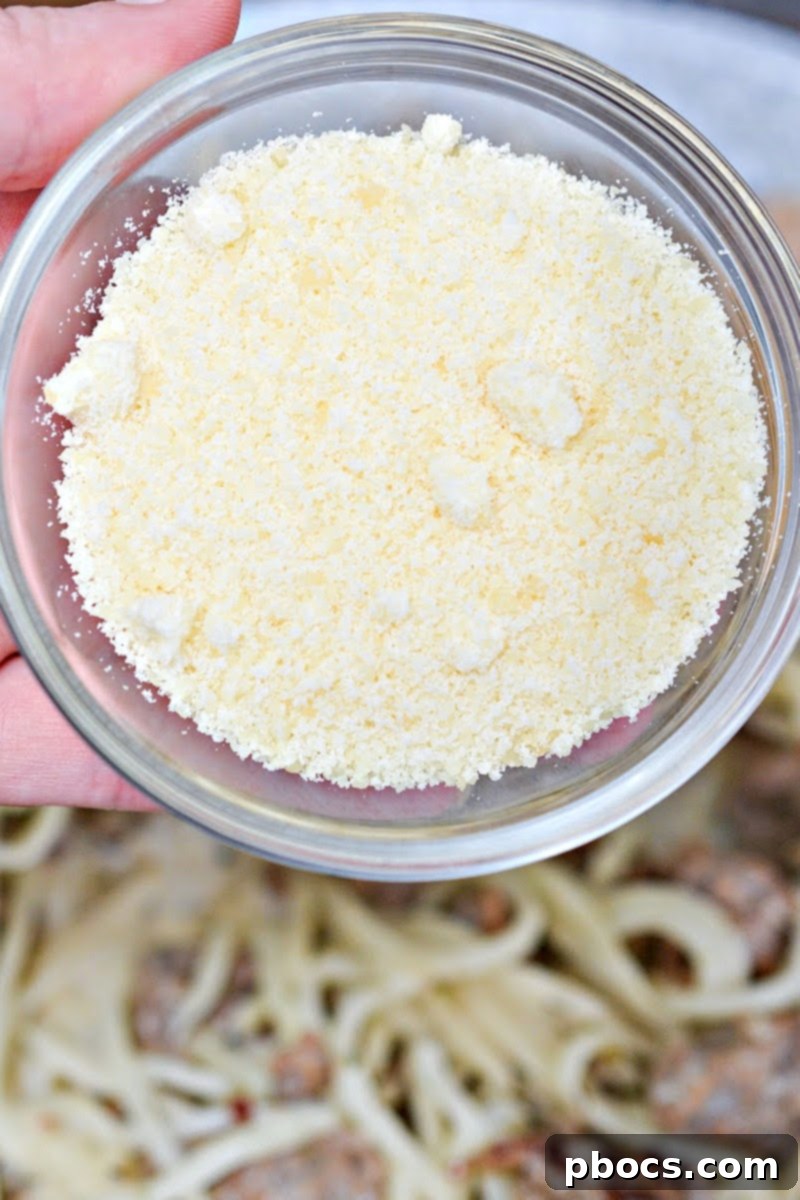 Grated Parmesan cheese being sprinkled into the skillet for the sauce.