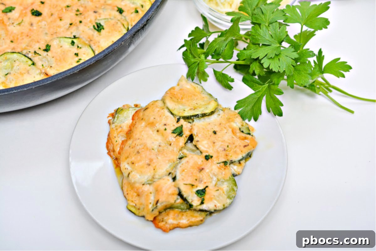 A cast iron skillet filled with cheesy scalloped zucchini, freshly baked and bubbling.