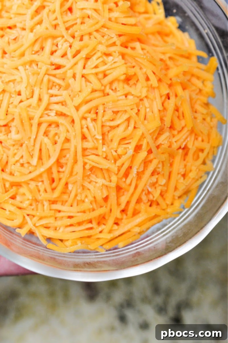 Close-up of shredded cheddar cheese, one of the key ingredients for a rich and creamy scalloped zucchini.