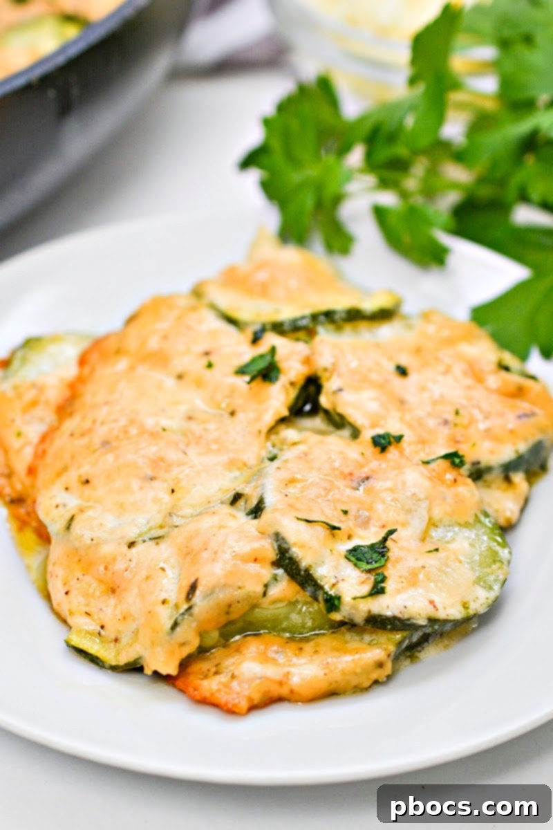 A serving of Keto Scalloped Zucchini on a plate, showing the creamy sauce and tender zucchini slices.