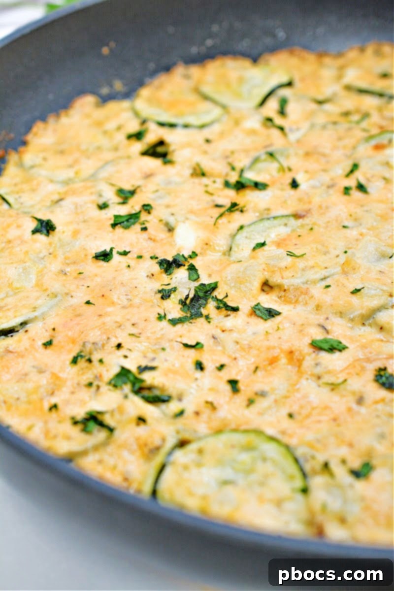 Close-up of Keto Scalloped Zucchini in a cast iron skillet, ready to be served.