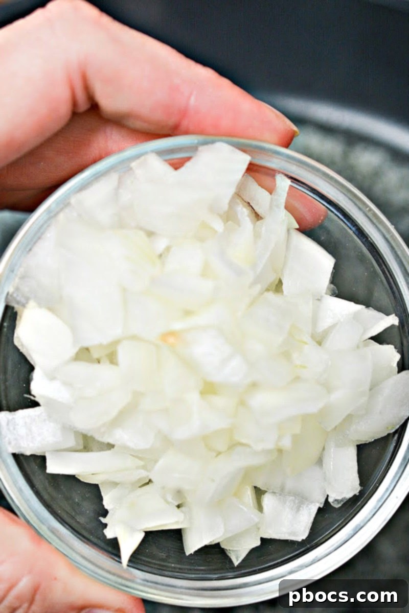 Diced onions sautéing in a skillet with butter.