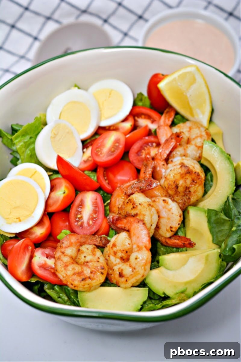 Assembling the Low-Carb Shrimp Louie Salad with fresh toppings.