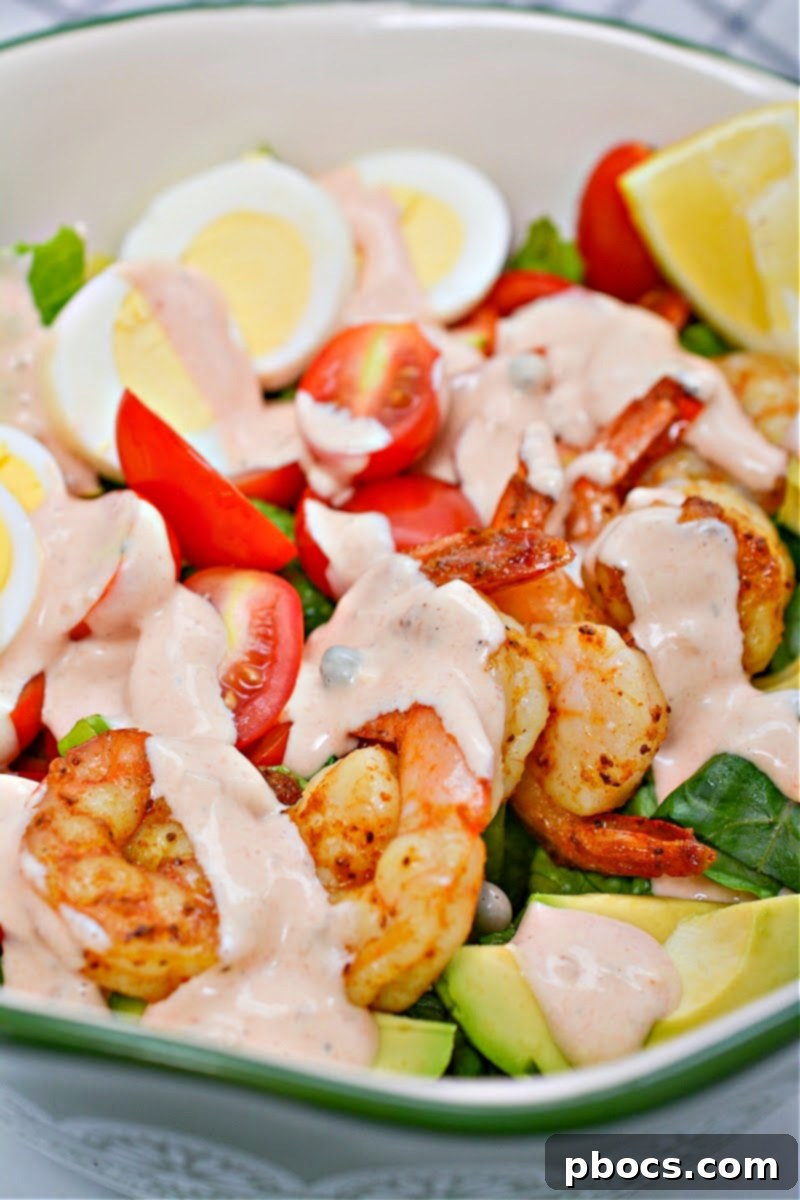 Classic Shrimp Louie Salad ingredients on a bed of fresh greens.