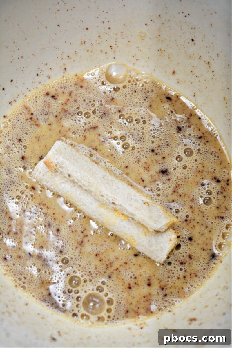 Dipping French Toast Roll Ups into the egg batter