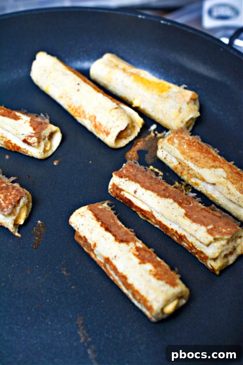 Cooking French Toast Roll Ups in a hot skillet until golden brown
