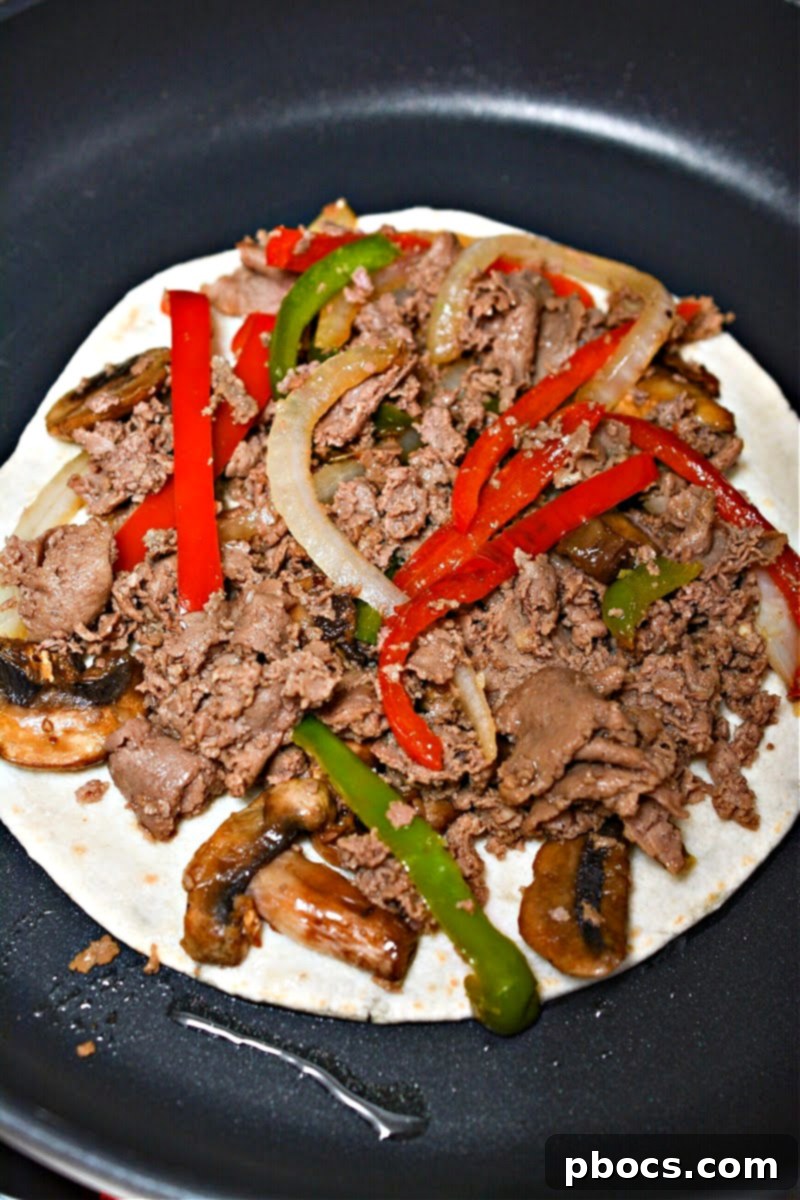 Cheesy Keto Philly Quesadillas 14 Adding peppers and meat to the quesadilla