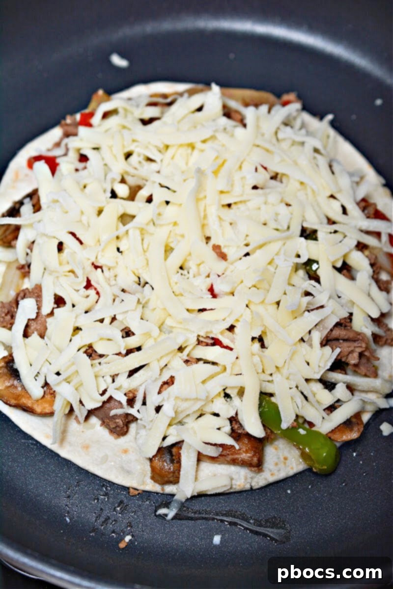 Cheesy Keto Philly Quesadillas 15 Adding cheese to the quesadilla