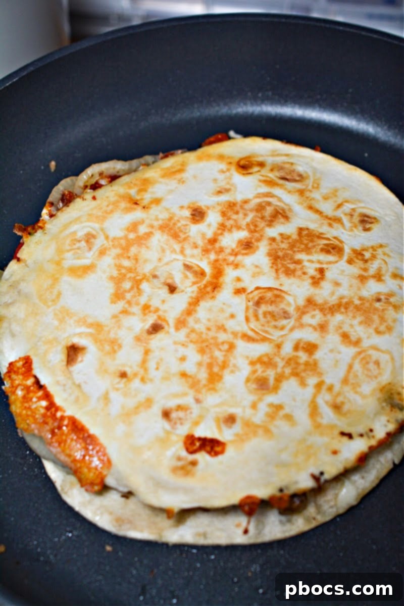 Cheesy Keto Philly Quesadillas 16 Keto Loaded Philly Cheesesteak Quesadillas frying in a skillet