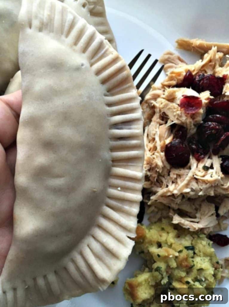 Turkey, Stuffing & Cranberry Empanadas Sealing empanada edges with a fork