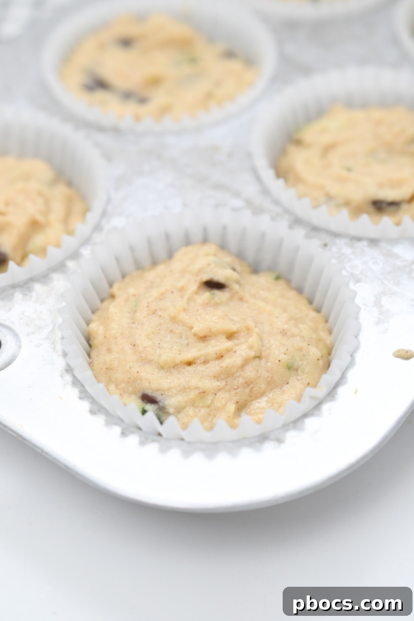 Irresistible Keto Chocolate Chip Zucchini Muffins 11 Unbaked muffin batter in a muffin tin ready for the oven