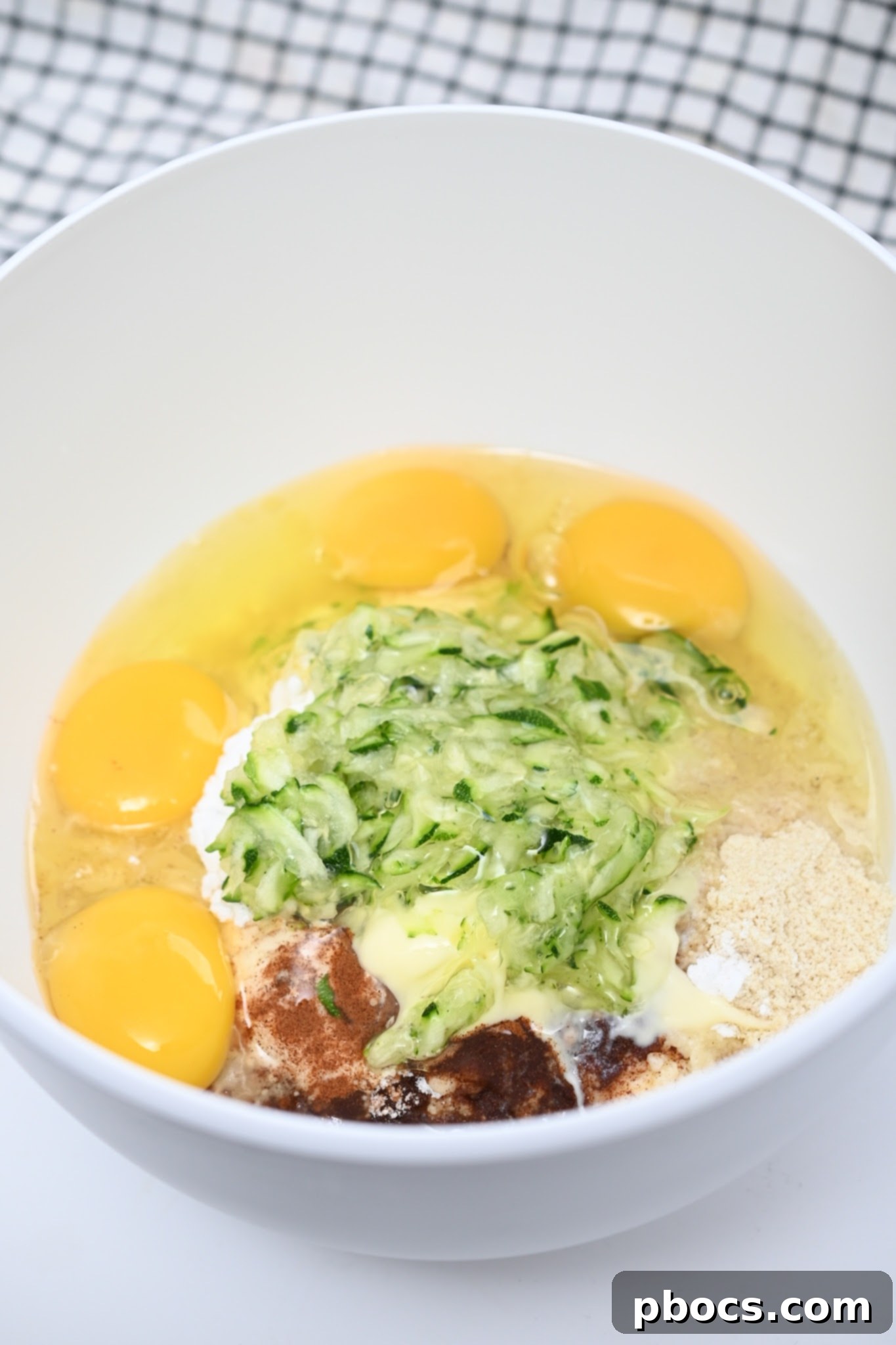 Irresistible Keto Chocolate Chip Zucchini Muffins 9 Ingredients for keto muffin batter in a mixing bowl before combining