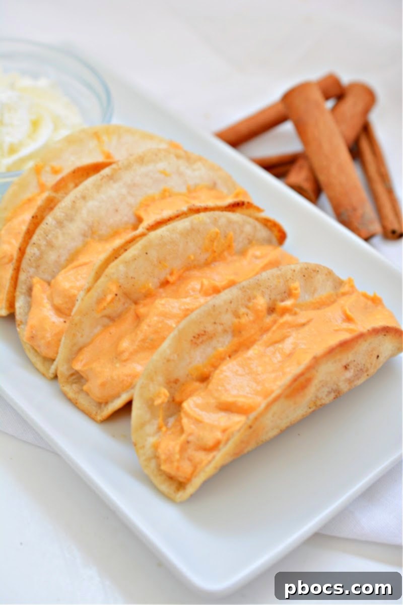 Spoonfuls of rich pumpkin pie filling being added into crispy taco shells.