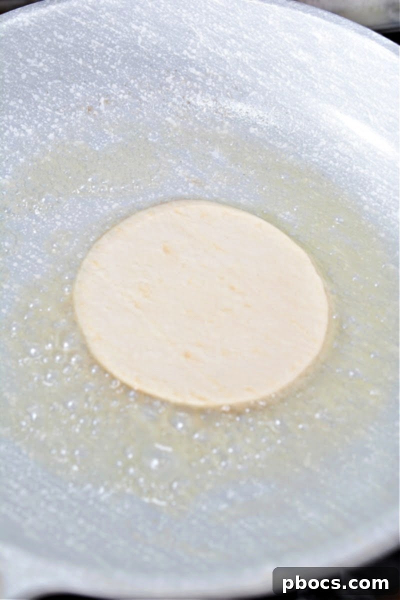 Melting butter in a skillet over medium heat, preparing for frying tortillas.