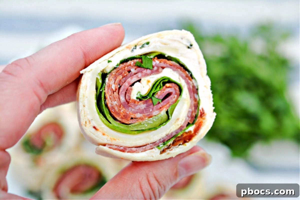 Keto Italian Swirls 3 Close-up of freshly sliced Keto Italian Pinwheels on a wooden board, showcasing the layers of ingredients.