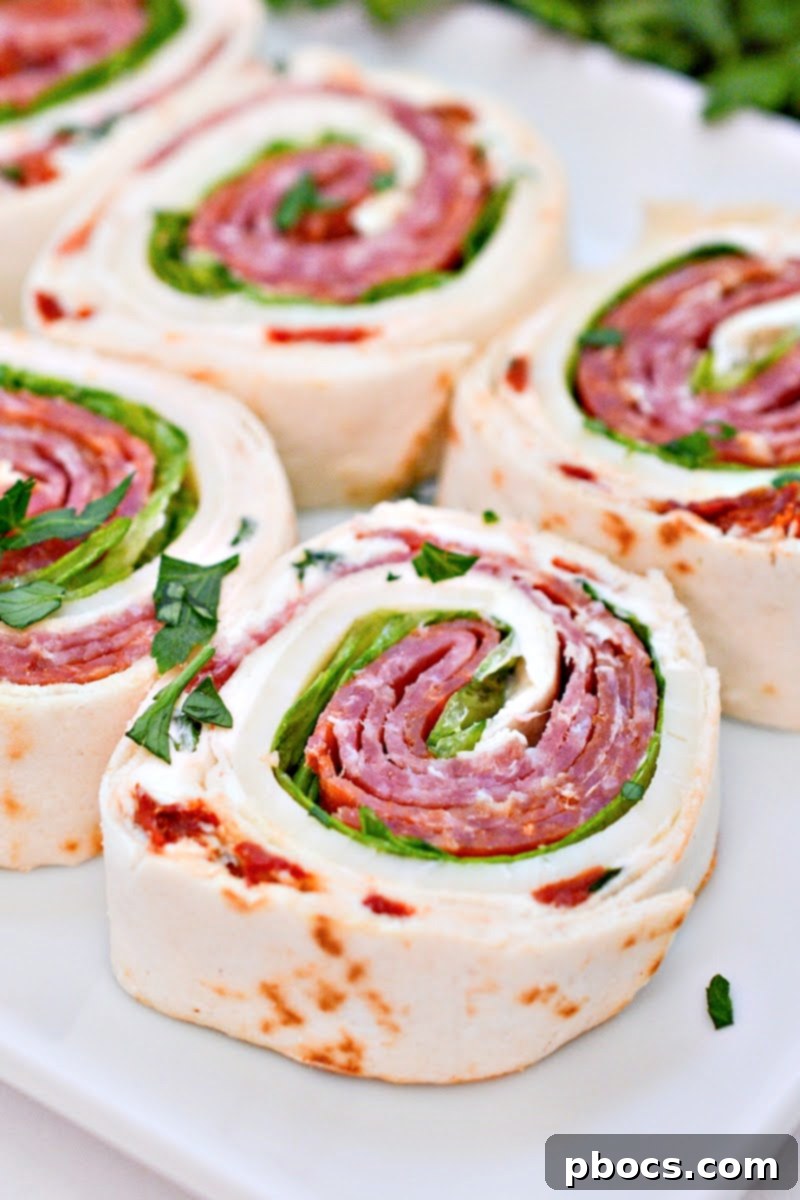 Keto Italian Swirls 5 An overhead view of the ingredients assembled on a tortilla before rolling for Keto Italian Pinwheels.