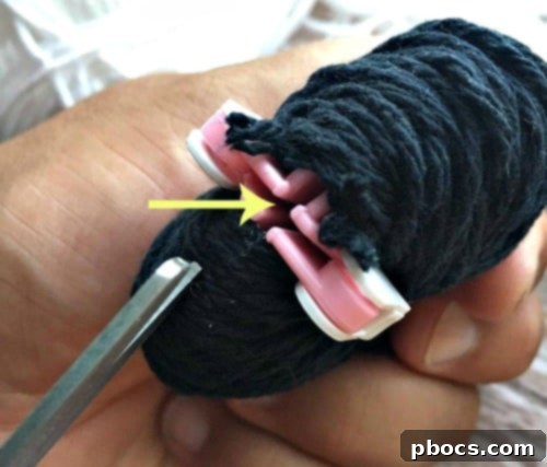 Tying the center of the pom pom with yarn