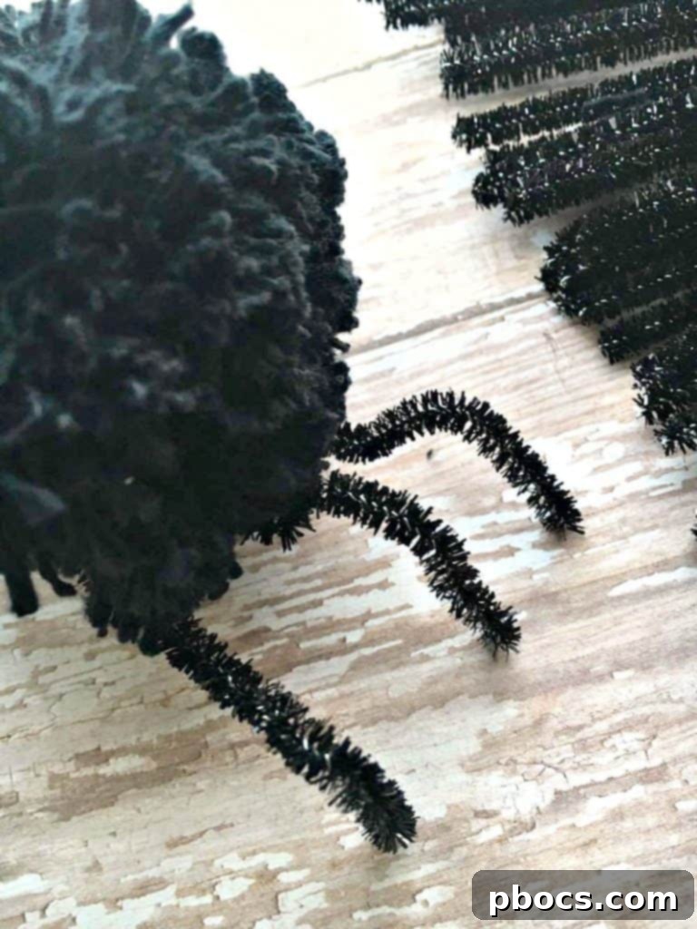 Shaping the pipe cleaner legs of a pom pom spider