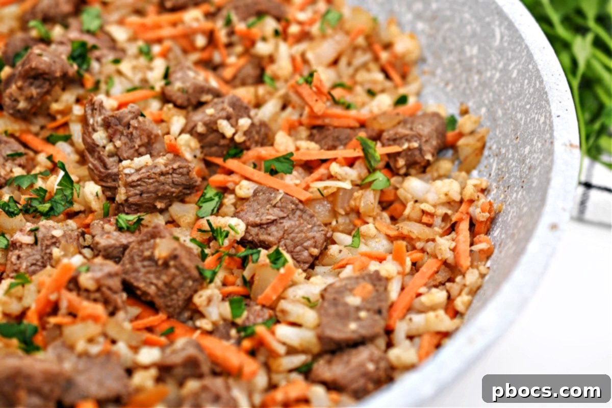 Low-Carb Beef Cauliflower Rice Pilaf in a skillet, garnished with parsley