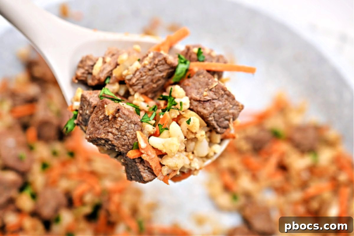 Plate of Low-Carb Beef Cauliflower Rice Pilaf garnished with fresh herbs