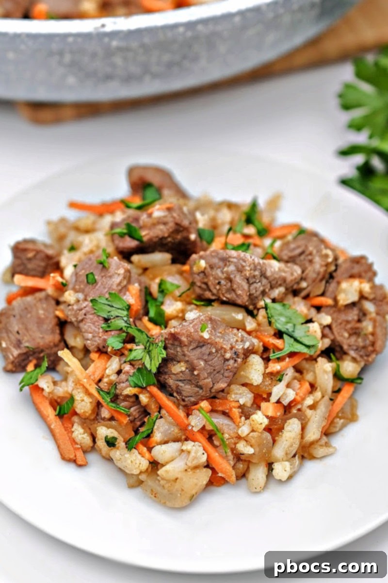 A bowl of Low-Carb Beef Cauliflower Rice Pilaf on a patterned tablecloth