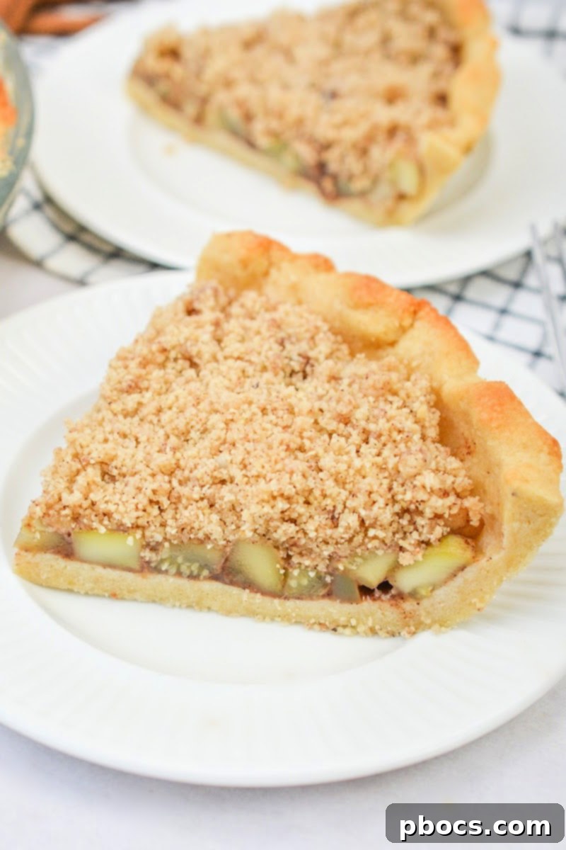 A slice of Keto Apple Pie, showcasing its golden crumble top and rich filling.