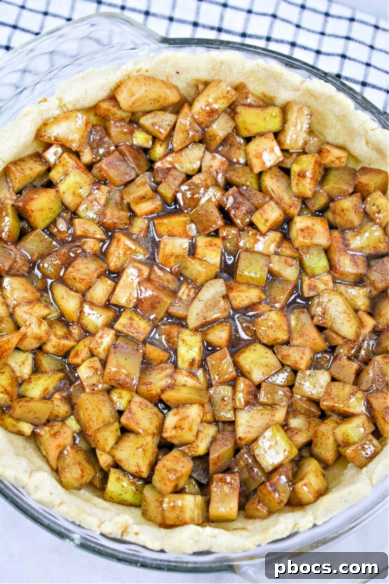 The cooked zucchini filling, coated in rich brown spices, poured into the pre-baked keto pie crust.