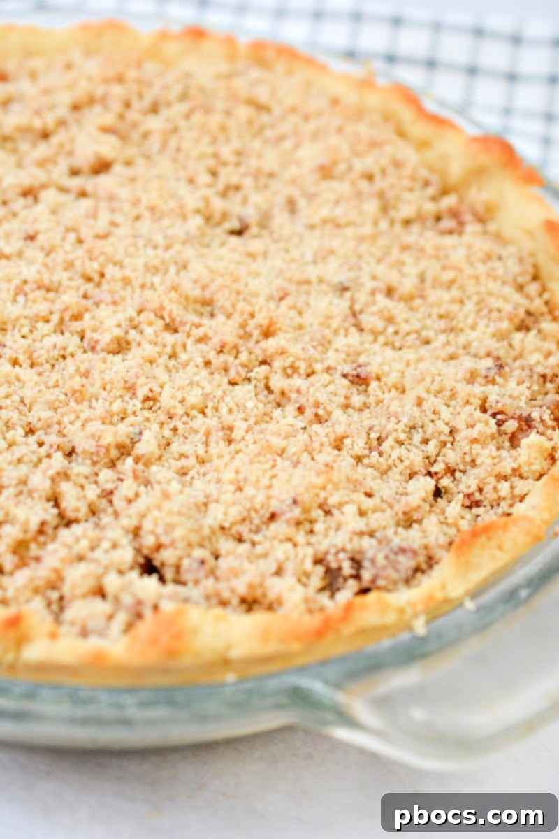 A whole Keto Apple Pie, perfectly baked with a golden-brown crumble crust, ready to be sliced.