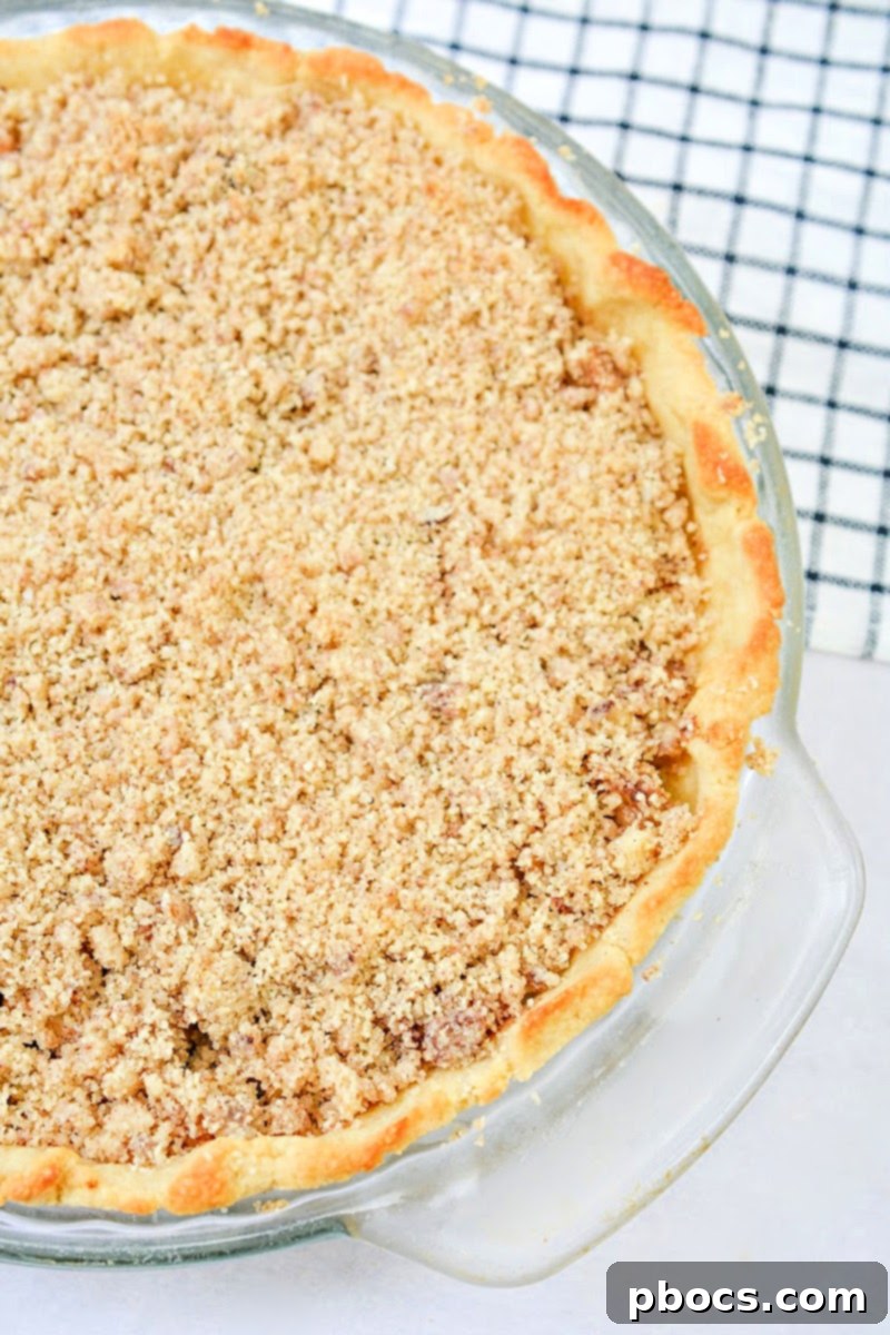 A perfectly plated slice of Keto Apple Pie, served with a dollop of whipped cream and a sprinkle of cinnamon.