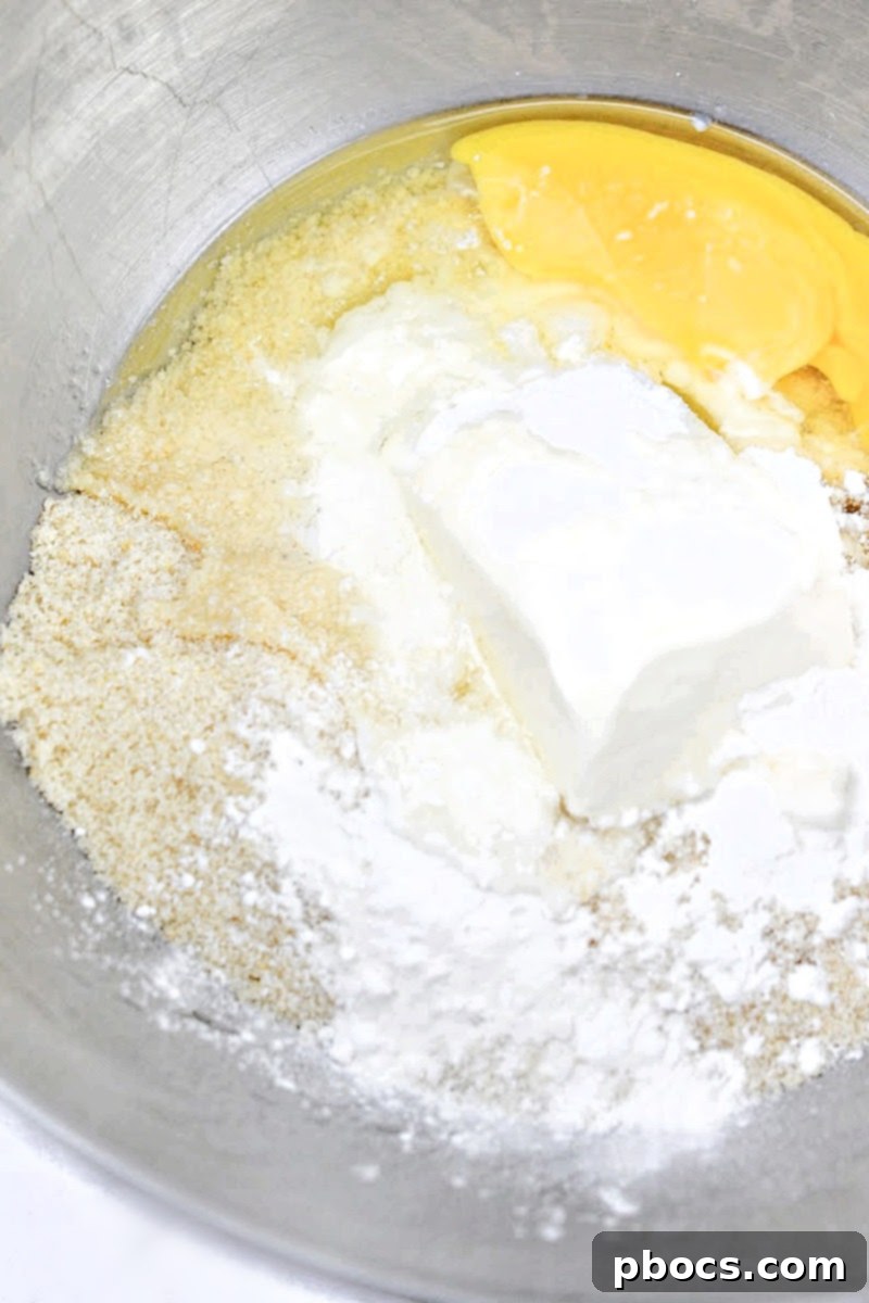 Mixing the keto pie crust ingredients in a bowl with a hand mixer until crumbly.