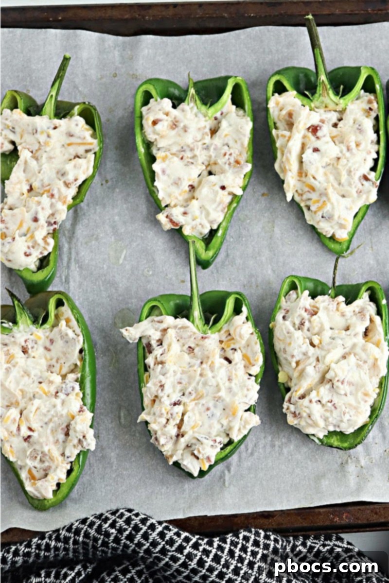 Adding cream cheese mixture to hollow poblano pepper halves