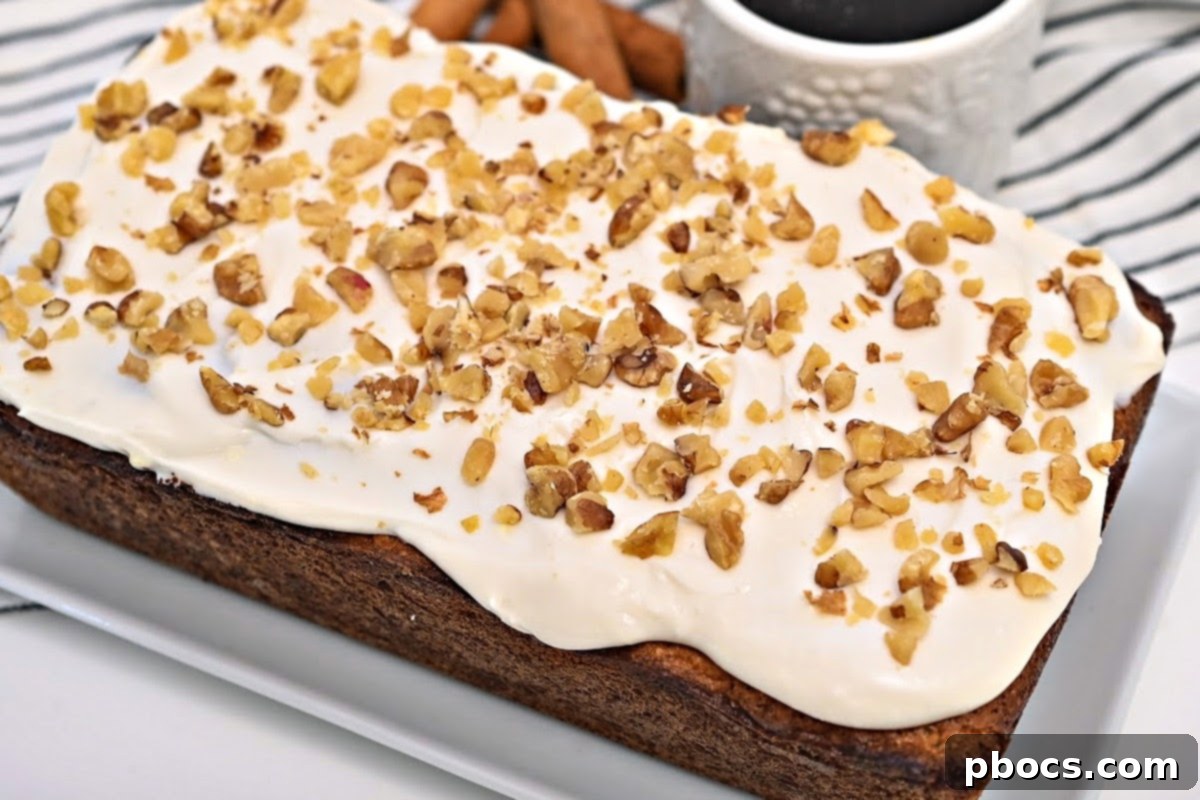 A beautifully frosted Keto Starbucks Gingerbread Loaf, topped with chopped walnuts, ready to be served.