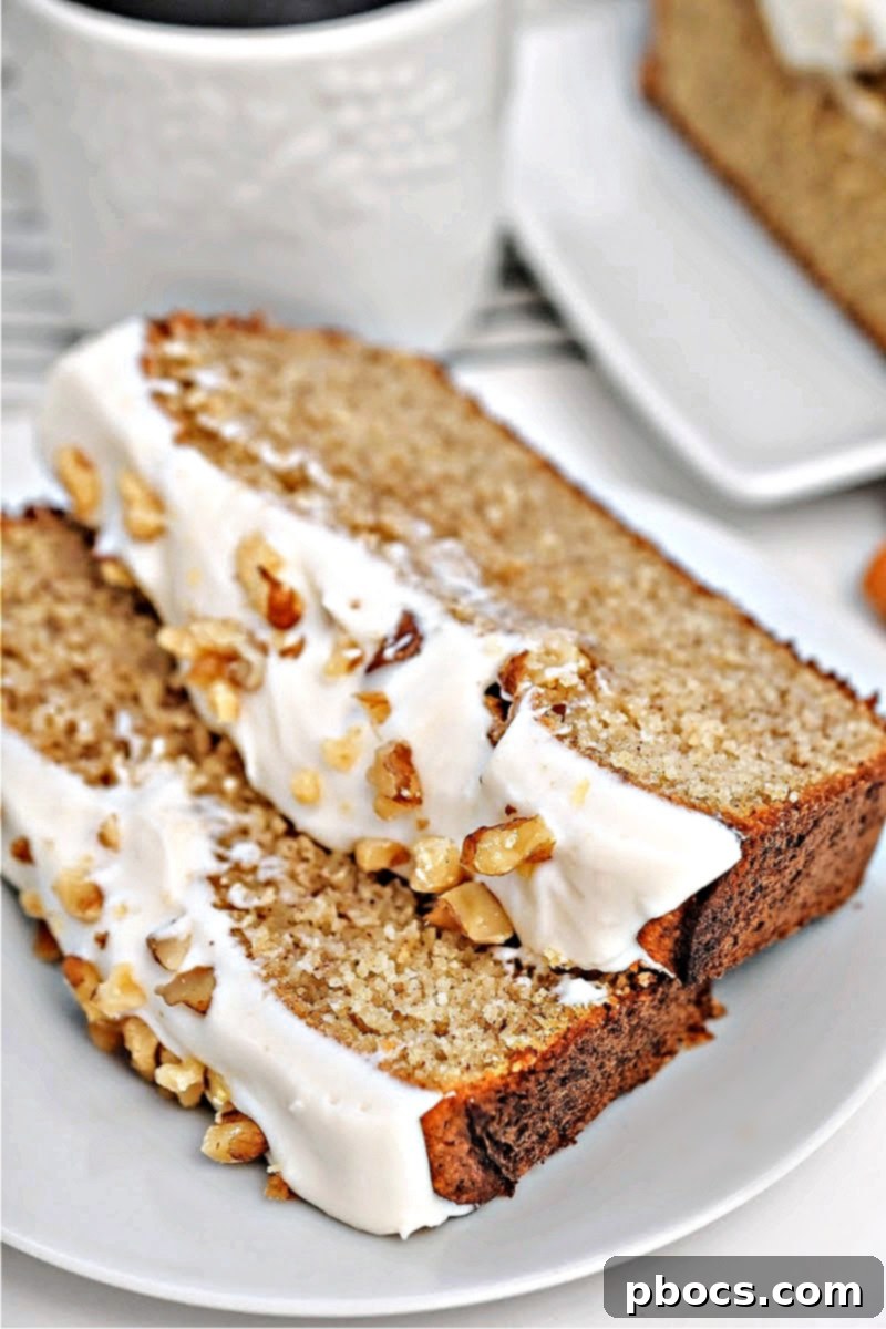 Two slices of the Keto Starbucks Gingerbread Loaf on a rustic wooden board, garnished for the holidays.