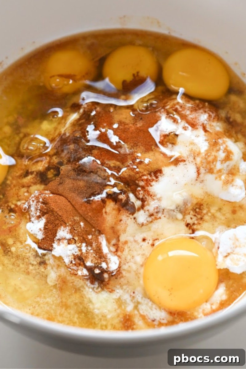 Mixing the wet and dry ingredients together in a large bowl to create the gingerbread loaf batter.