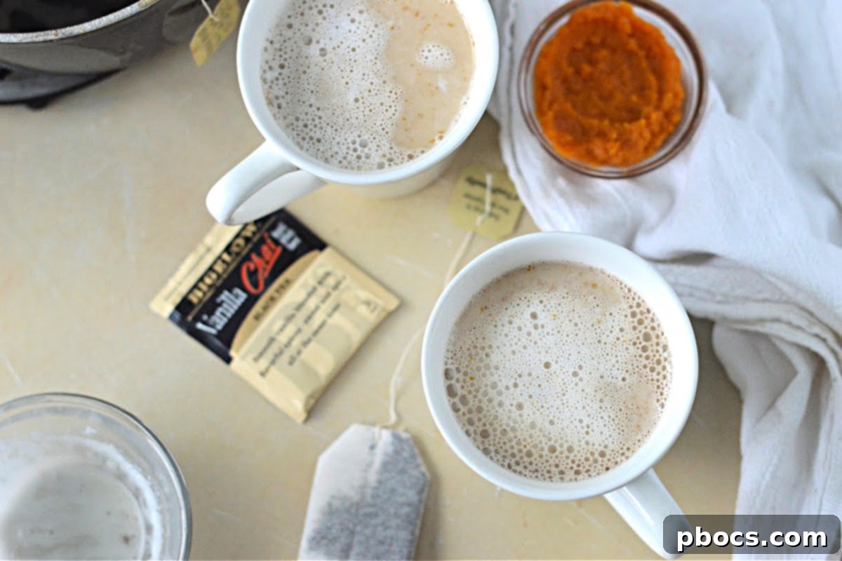 Pouring the finished pumpkin chai tea latte base into serving glasses.