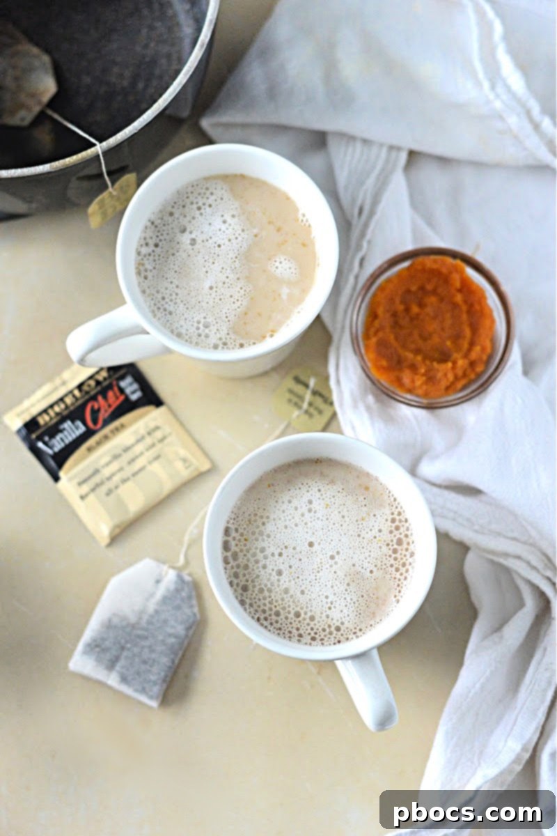 Pouring the pumpkin chai tea mixture into a glass for a refreshing fall drink.