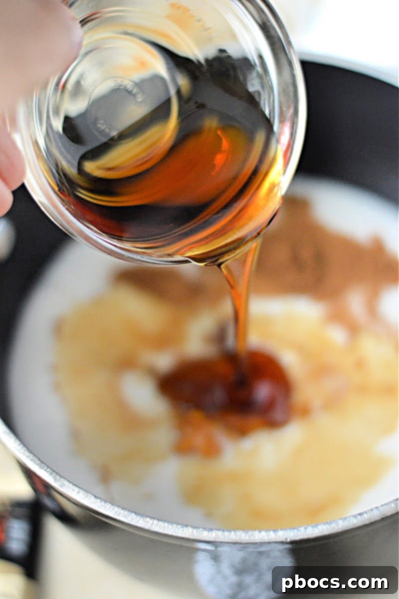 All ingredients for the latte base (almond milk, pumpkin, syrup, vanilla, spice, tea bag) in a pot on the stove.