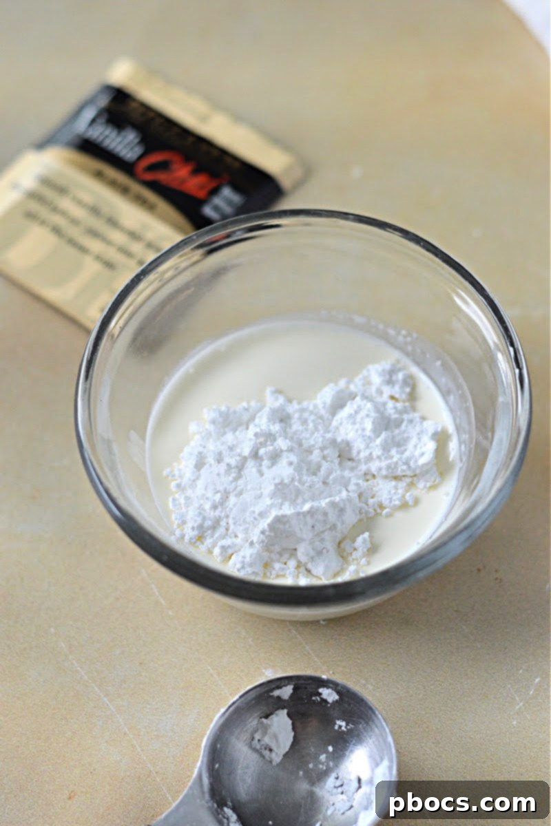 Whisking heavy whipping cream and Swerve confectioner's sugar for the sugar-free whipped cream topping.