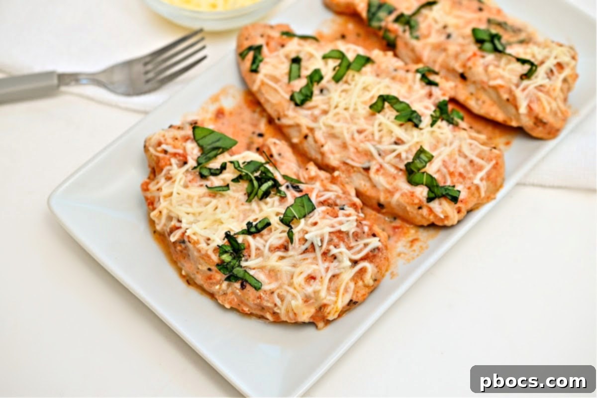 Keto Crockpot Tomato Alfredo Chicken, garnished with fresh basil.