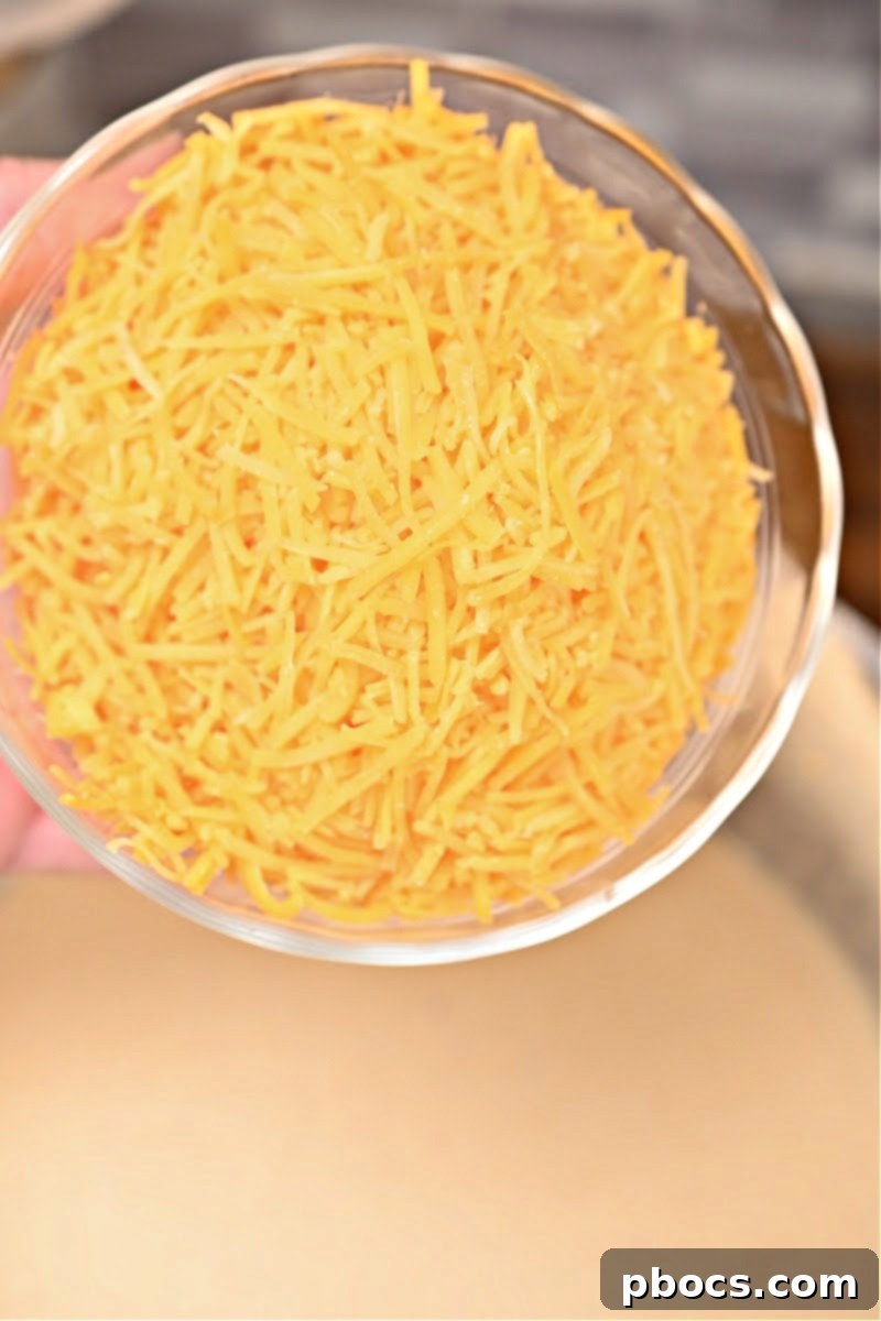 Whisking heavy whipping cream into the cheese sauce